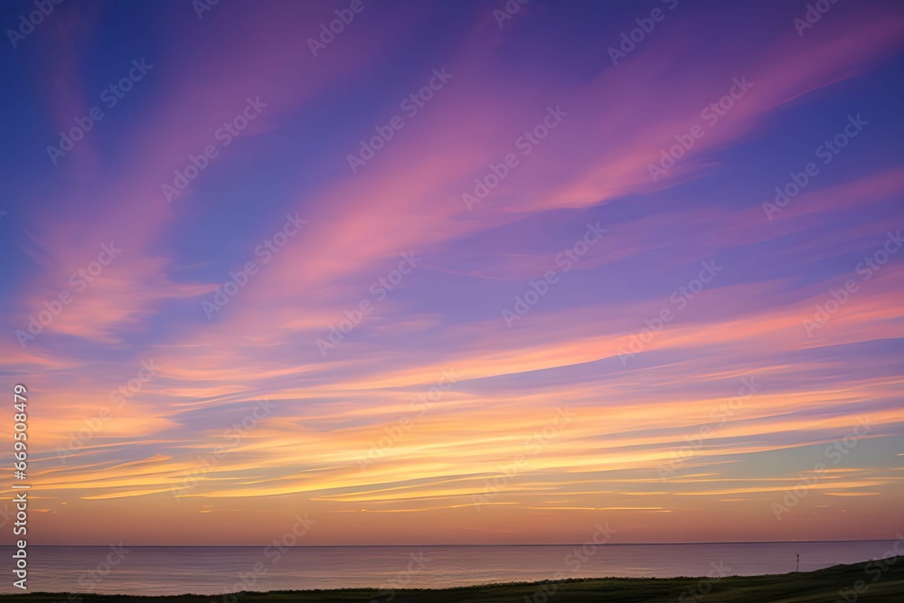 夕日に染まる空とシルエットの丘と静かな湖、オレンジとピンクの空が広がる風景