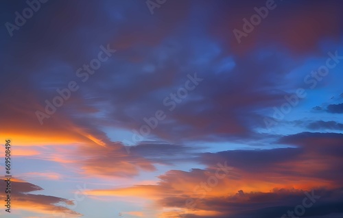 夕暮れの色彩：オレンジ、青、紫のグラデーションが広がる空と、暗くて細い雲が交差する、低角度から見上げた夕暮れの風景