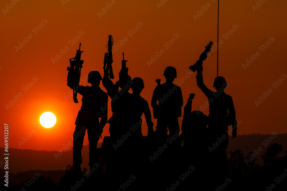 silhouette group of special forces sodiers standing and sit holding gun on cannon tank with over the sunset and colorful orange sky background, silhouette group of special forces sodiers standing and sit holding gun on cannon tank with over the sunset and colorful orange sky background,