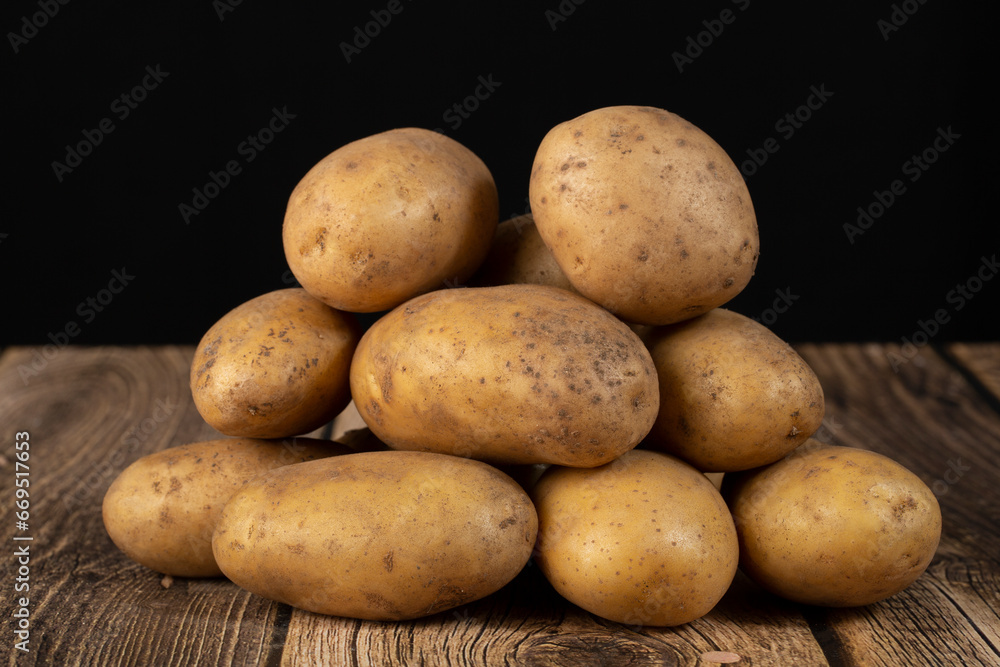 White potatoes on a dark background. Sale of fresh potatoes. White potatoes on a dark background. Sale of fresh potatoes.