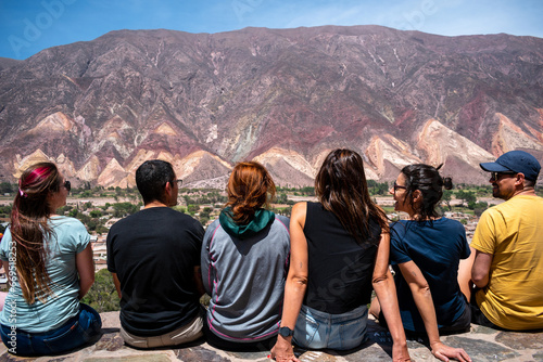 Amigos sentados en el mirador de Maimará admirando los cerros coloridos photo