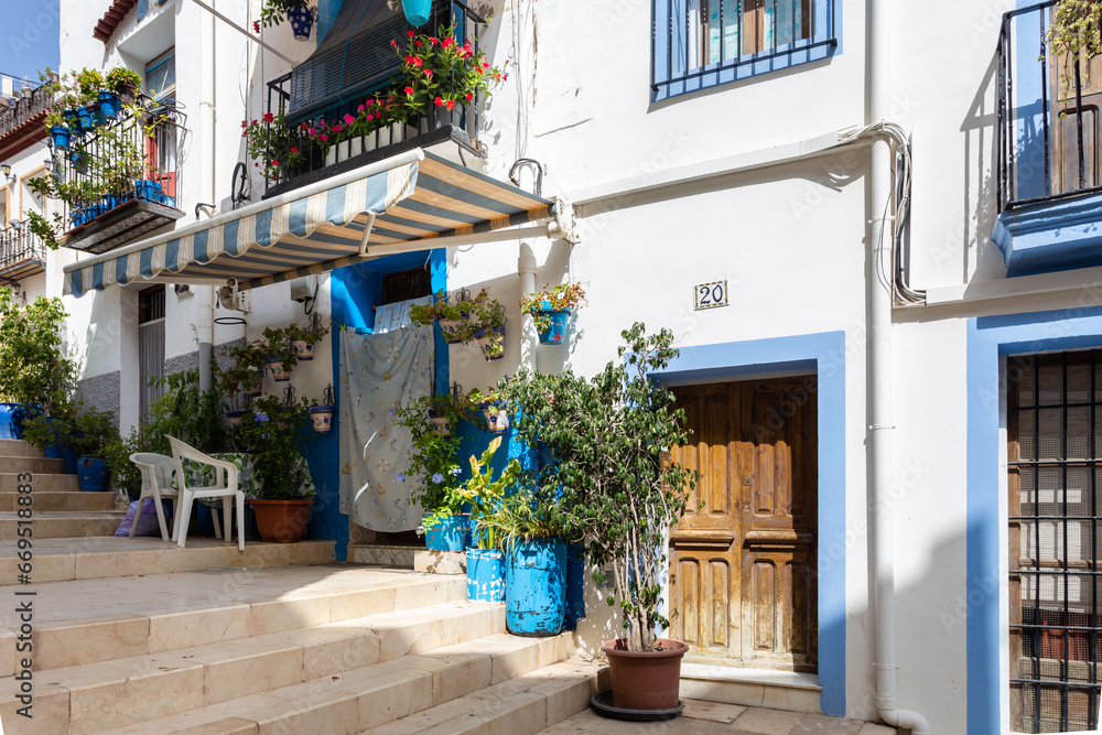 Blue and white houses in typical street in Barrio Santa Cruz in Alicante, Costa Blanca, Spain