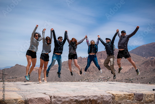 Grupo de amigos saltando coordinadamente en la Quebrada de Humahuaca, en Jujuy