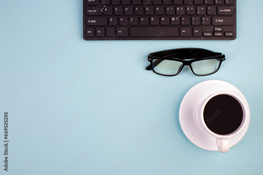 Desktop. Top view with copy space. Keyboard, glasses, cup of coffee on a light background. Desktop. Top view with copy space. Keyboard, glasses, cup of coffee on a light background.