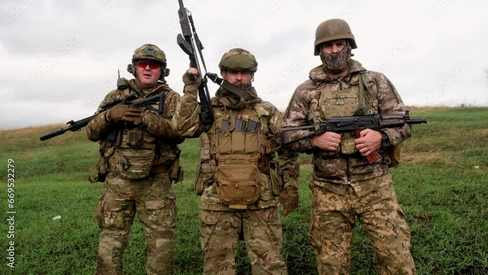 Military men with weapons on an open-air field. Concept of military operations and armed forces. Military men with weapons on an open-air field. Concept of military operations and armed forces.