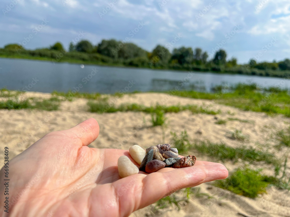 multicolored stones lie on the yellow river sand on the beach multicolored stones lie on the yellow river sand on the beach