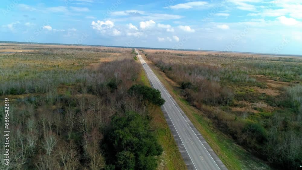 Aerial Forward Shot Of Vehicles On Road Amidst Plants Against Cloudy Sky - New Orleans, Louisiana Aerial Forward Shot Of Vehicles On Road Amidst Plants Against Cloudy Sky - New Orleans, Louisiana