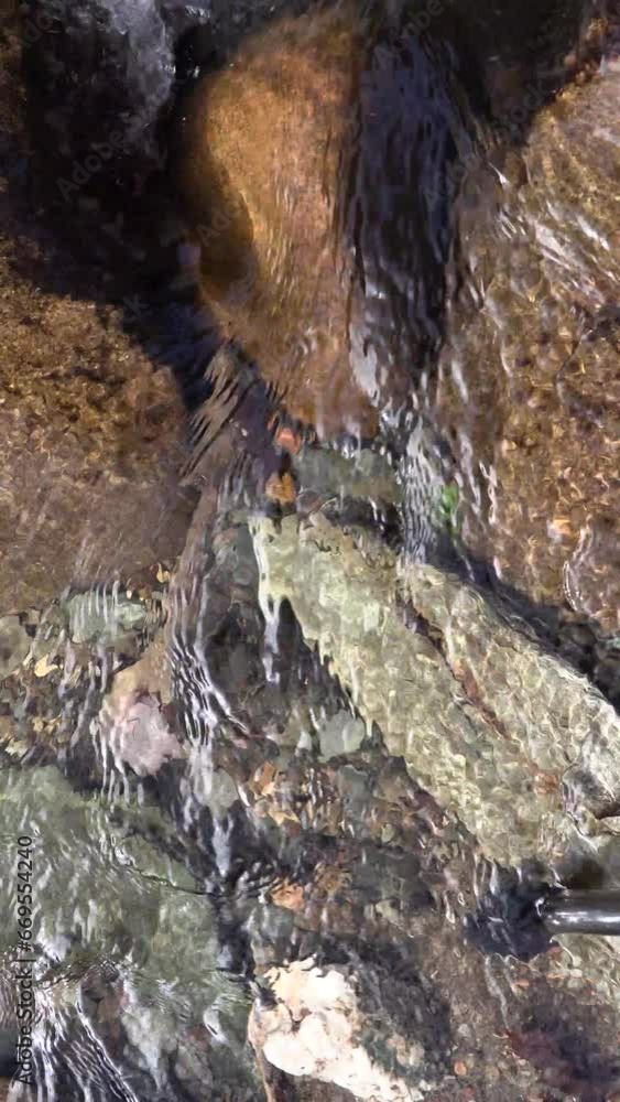 Clear mountain river water flowing over river rocks in fall colors
