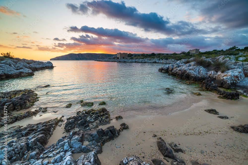 Sunset sky over beautiful beach and water bay in the greek spectacular coast line. Reflection on water, unique rocky cliffs, Greece summer top travel destination Mani peninsula Peloponnese
