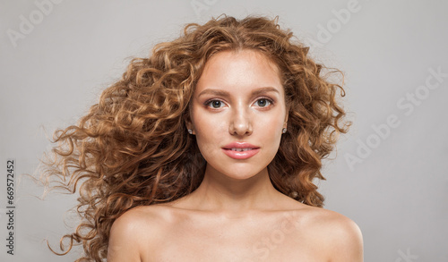 Healthy redhead female model with wavy hairstyle. Pretty young woman with healthy curly hair, fashion portrait