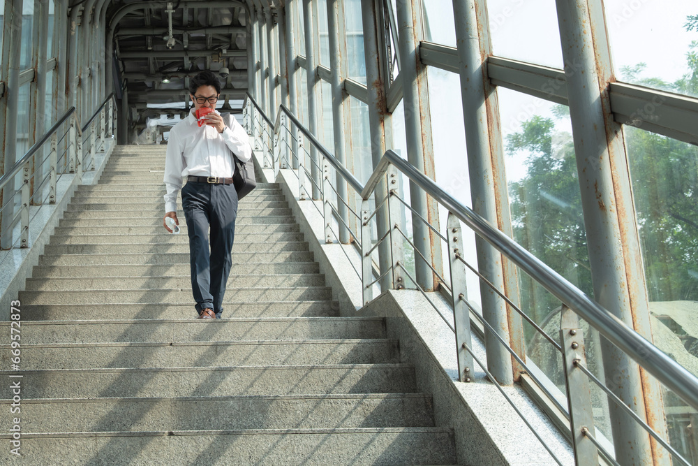 A middle-aged man eating while walking A middle-aged man eating while walking