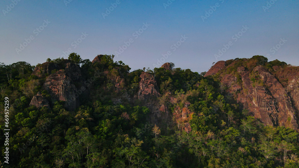 Drone photo of rocky mountain side of Nglanggeran prehistoric volcano, Yogyakarta, Indonesia - 4K drone shot Drone photo of rocky mountain side of Nglanggeran prehistoric volcano, Yogyakarta, Indonesia - 4K drone shot