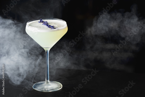 Margarita Cocktail served with eating purple flowers on dark background with copy space photo
