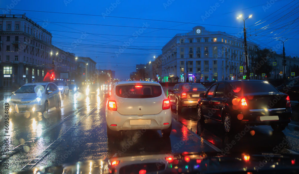 Car traffic on a wet street in the evening Car traffic on a wet street in the evening