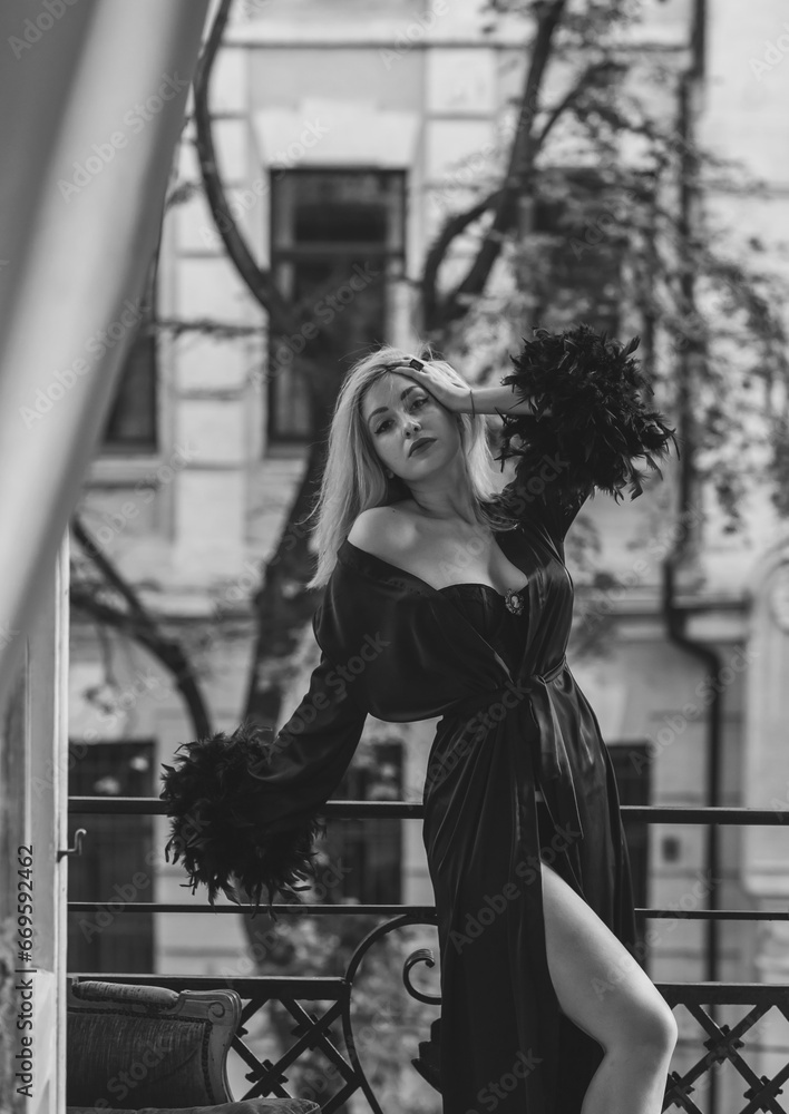 Elegant blonde woman in luxury black silk robe with a feathers. Woman wardrobe, perfection in every wardrobe details Elegant blonde woman in luxury black silk robe with a feathers. Woman wardrobe, perfection in every wardrobe details