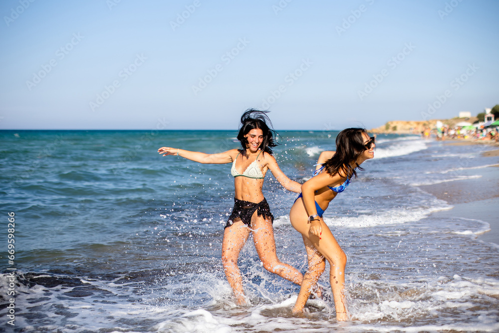 Two pretty young woman having fun on the seaside