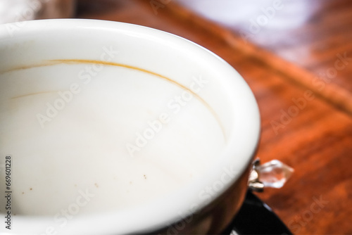 An empty white mug with coffee marks stuck to the inside. Isolated on White Background. Dirty stained coffee cup after used.