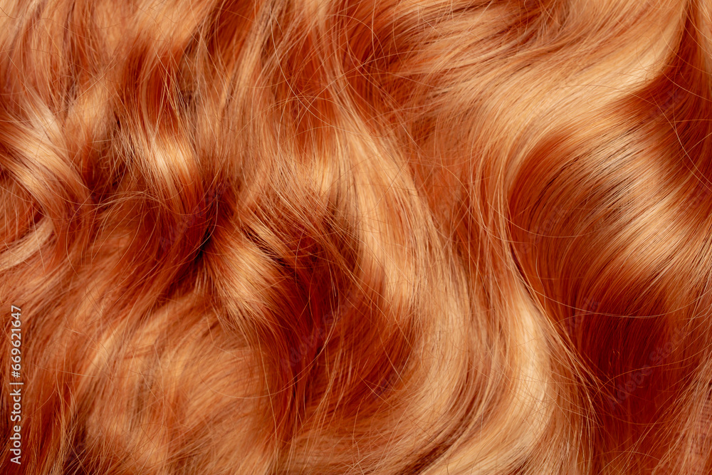 Red hair close-up as a background. Women's long orange hair. Beautifully styled wavy shiny curls. Hair coloring bright shades. Hairdressing procedures, extension. Red hair close-up as a background. Women's long orange hair. Beautifully styled wavy shiny curls. Hair coloring bright shades. Hairdressing procedures, extension.