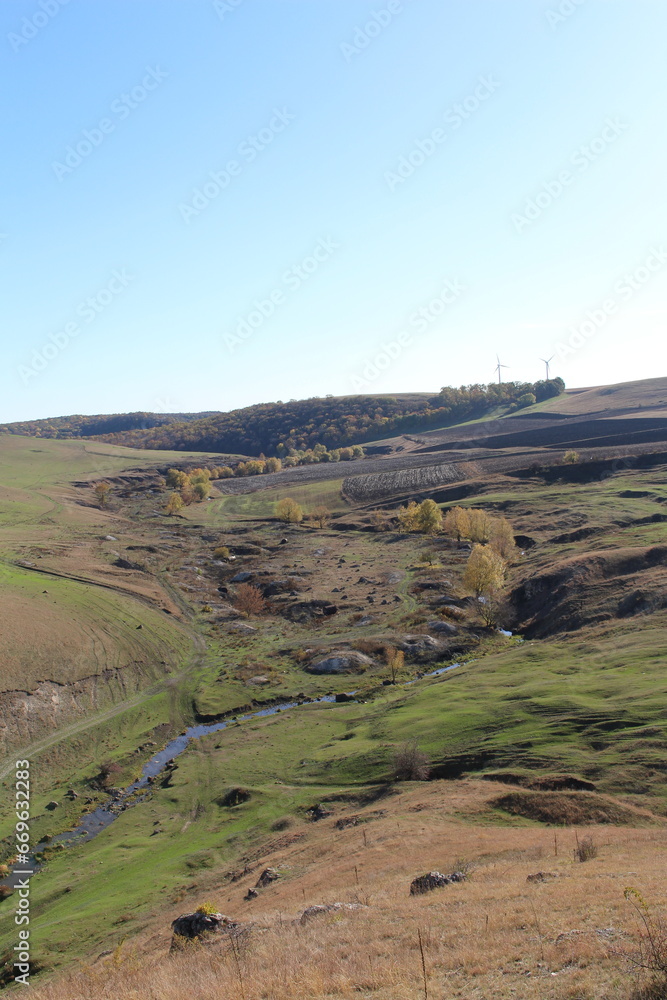 A landscape with a river and a blue sky