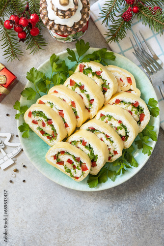 Creative appetizers christmas. Cheese roll with cream cheese, sweet pepper and greens. View from above. Copy space.