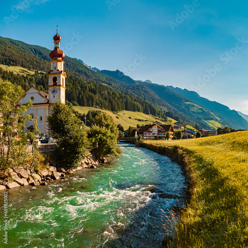 Alpine summer view with a church and the river Ahr at St Johann, San Giovanni, Ahrntal valley, Pustertal, Trentino, Bozen, South Tyrol, Italy photo