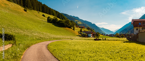 High resolution stitched alpine summer panorama with labouring peasants at St Johann, Ahrntal valley, Bozen, South Tyrol, Italy photo