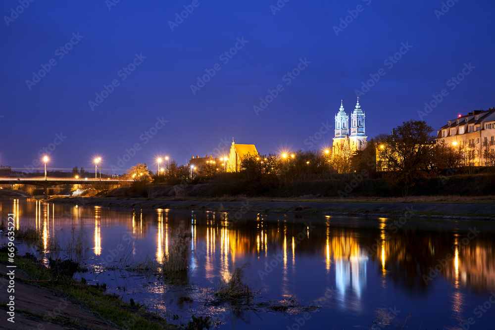 bridge over the river Warta and gothic cathedral at night in Poznan