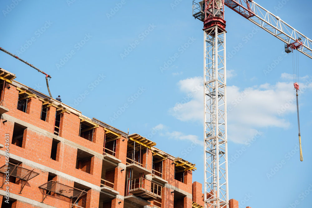 The brick building under construction is multi - storey and The brick building under construction is multi - storey and