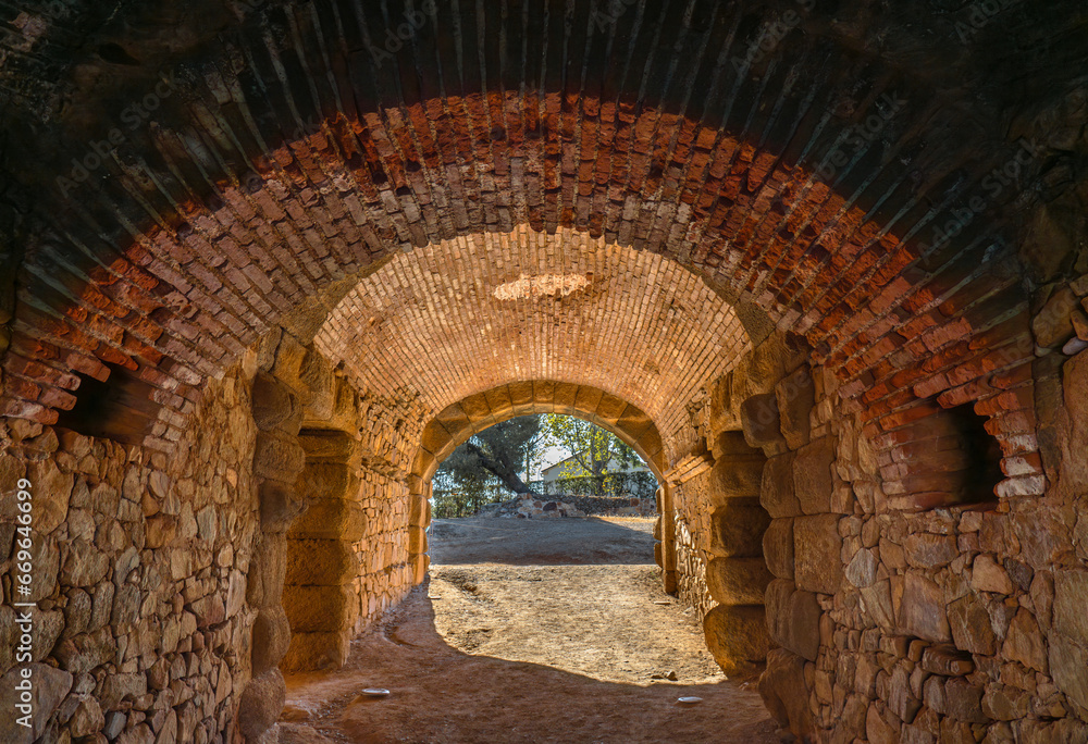 Corridor Interior of the entrance and exit of the ancient Roman Theater of Mérida, with a vaulted ceiling of brick and granite stones with the light of the dawn sun entering through the tunnel.