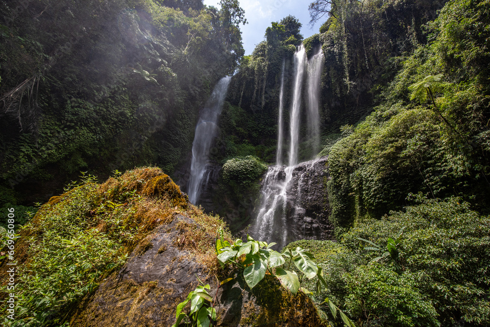 The Sekumpul Waterfall, a large waterfall in the middle of the jungle that falls into a deep green gorge. Trees and tropical plants at Bali's highest waterfall.