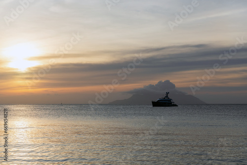 Ocean view with silhouette of a yacht under sunset sky.Seychelles