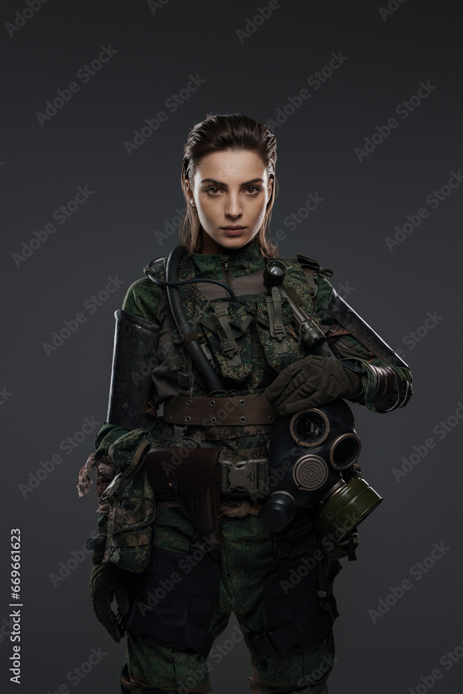 Portrait of a woman in military attire, portraying a rebel or partisan, against a gray background, depicting a Middle Eastern conflict Portrait of a woman in military attire, portraying a rebel or partisan, against a gray background, depicting a Middle Eastern conflict