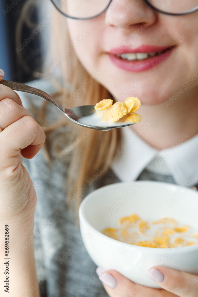Closeup of mouth-eating corn flakes with milk on breakfast, unrecognizable woman. Concept of healthy eating. Closeup of mouth-eating corn flakes with milk on breakfast, unrecognizable woman. Concept of healthy eating.
