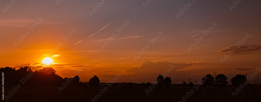 Obraz premium Sunset with a dramatic sky and overland high voltage lines near Tabertshausen, Deggendorf, Bavaria, Germany