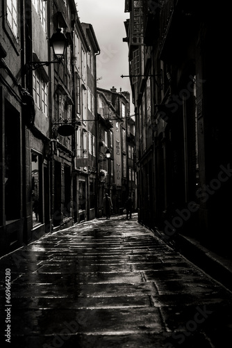 A narrow street in Santiago de Compostela after rain. Spain. Black and white photography.