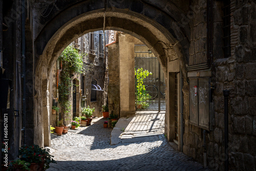 a narrow cobbled street with typical architecture in the medieval old town of Viterbo, Lazio, Italy photo