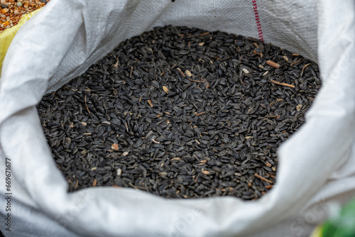 Sunflower seeds in a sack with an open corner. Food for birds in bags. Seed mixture. The view from top. 