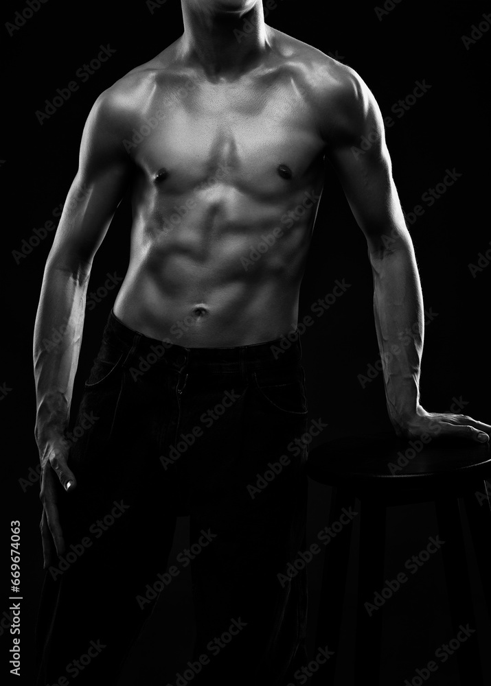 Naklejka premium Silhouette of a slender muscular man doing sports in the gym. Sports and healthy lifestyle.