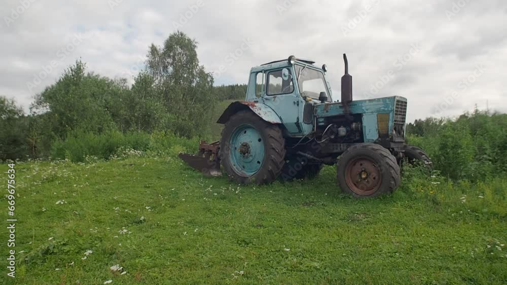 An old village tractor stands in a field. An old village tractor stands in a field.