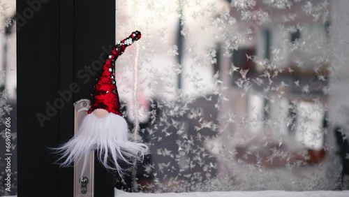 Little christmas gnome gonk outdoors on frozen window photo