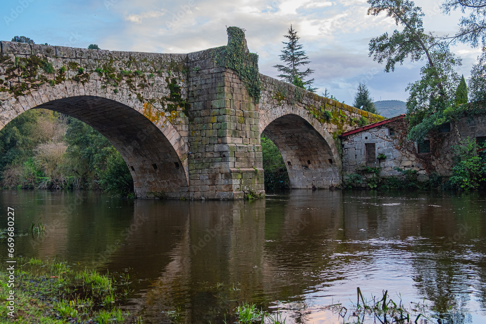 Medieval stone bridge over the Arnoia river in the town of Allariz. Province of Ourense. Galicia, Spain
