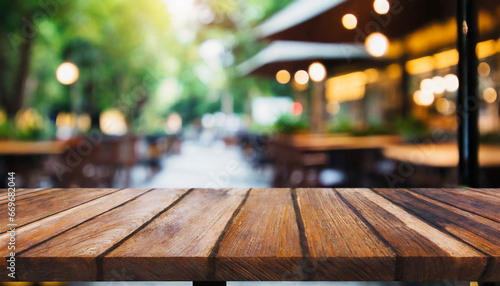 empty wooden table and abstract blurred background of coffee shop or restaurant outdoor