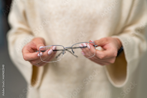 A Woman Embracing Eyewear Elegance. A woman holding a pair of glasses in her hands