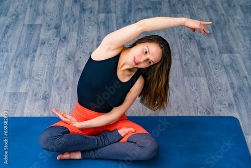 Yoga Bliss: Serene Woman Practicing Flow on Vibrant Blue Mat. A woman in a yoga pose on a blue mat