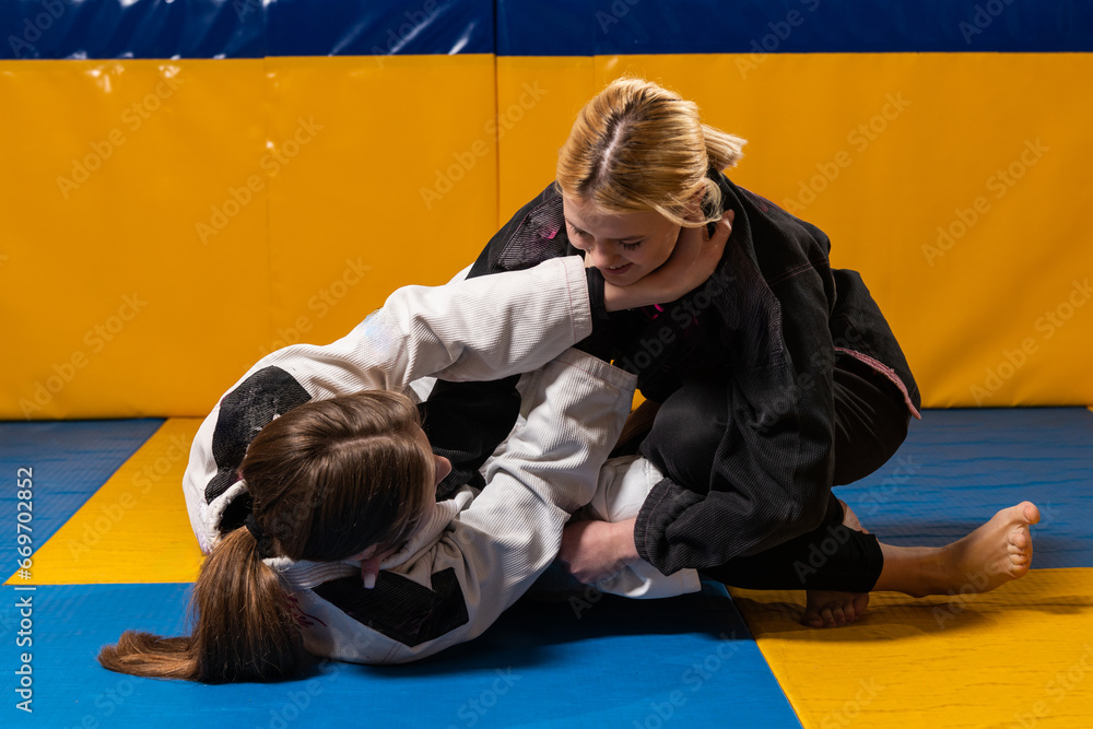 Young girls practice Brazilian jiu jitsu in the gym Young girls practice Brazilian jiu jitsu in the gym