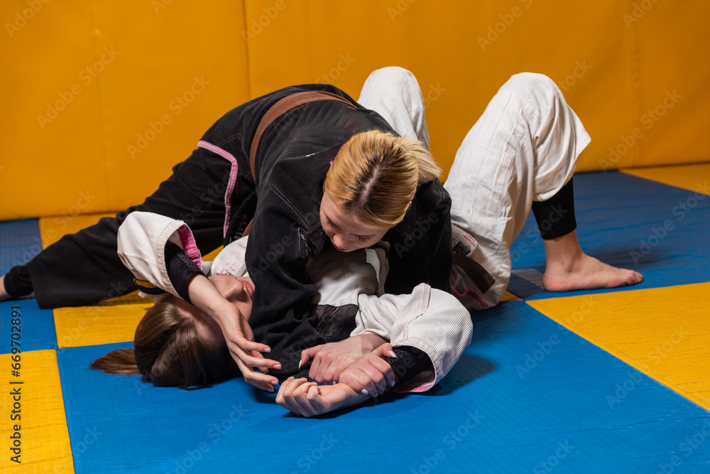 Young girls practice Brazilian jiu jitsu in the gym Young girls practice Brazilian jiu jitsu in the gym