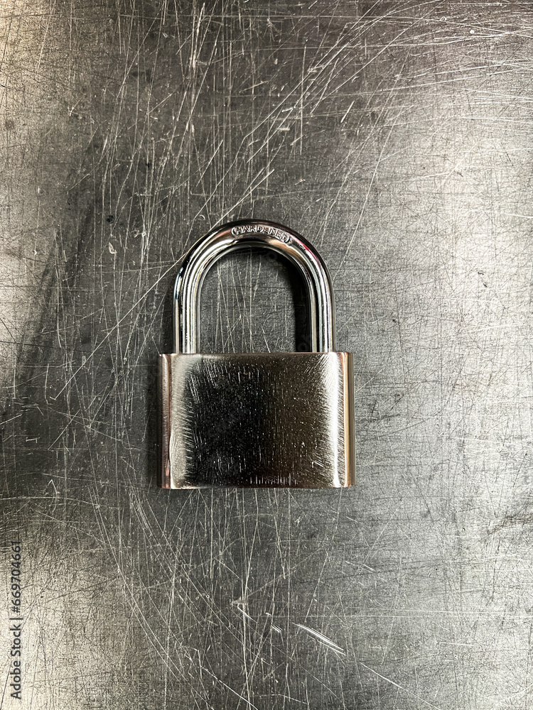 Fototapeta premium Metallic padlock on metal texture background