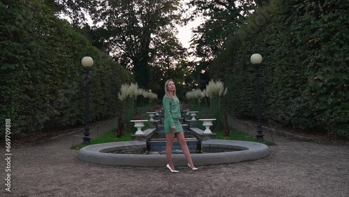 A woman poses in front of a fountain