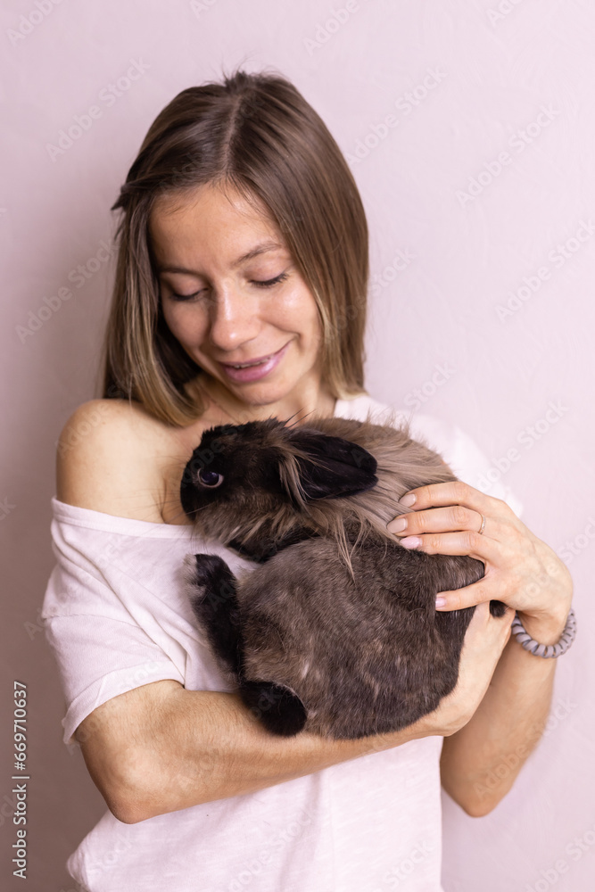 Close up woman holding cute fluffy rabbit, animal and pet concept Close up woman holding cute fluffy rabbit, animal and pet concept