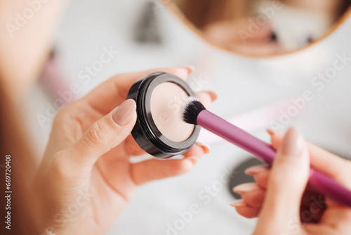 Eyeshadow palette background. Woman holding cosmetics in hand. Girl doing makeup. Premium luxury golden palette. Makeup kit with brush. Multicolor eye shadow. Glamour background.